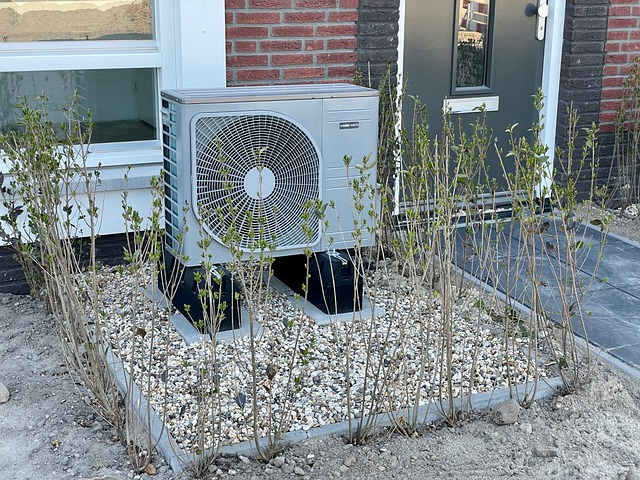 Heat pump in the front yard of a house