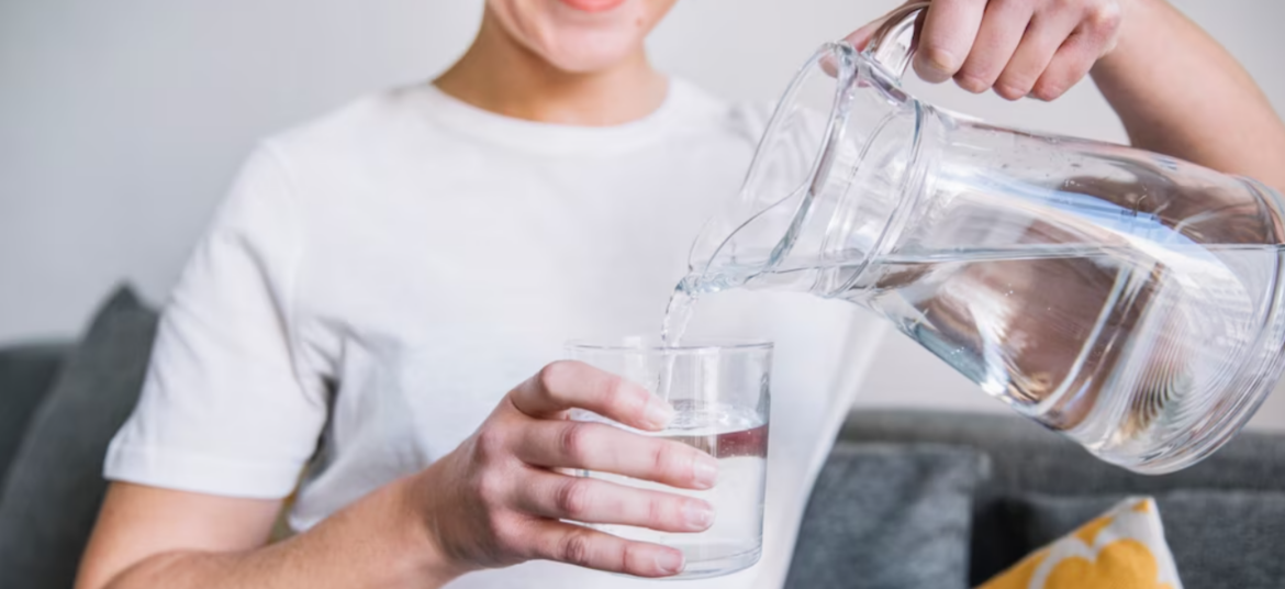 Woman pouring clean water into a glass