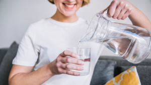 Woman pouring clean water into a glass
