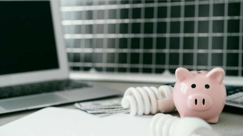 Piggy Bank with Lightbulbs on a Desk with a Laptop