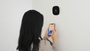 Woman Using an Ecobee Smart Thermostat